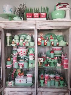 a cabinet filled with lots of green and red dishes on top of wooden shelves next to each other