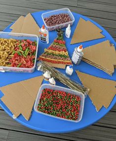 there are many different foods in plastic containers on the blue trays that have been made into christmas trees