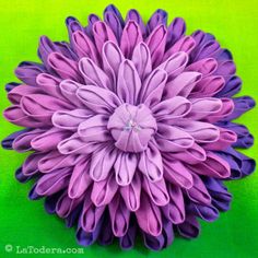 a large purple flower sitting on top of a green surface