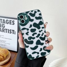 a woman holding up her phone case with an animal print pattern on the front and back