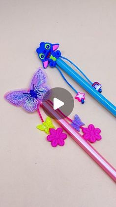 two toothbrushes with different designs on them and one has a butterfly attached to it