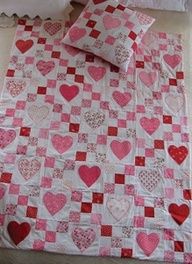 a bed with pink and white hearts on it