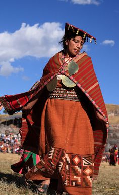 a woman in an orange and red dress holding a frisbee