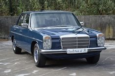 a blue mercedes benz parked in a parking lot