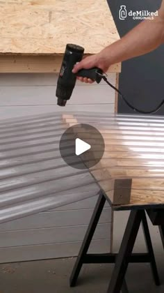 a person using a power drill to attach a piece of wood on top of a table