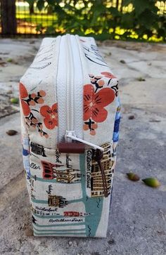 a piece of luggage sitting on top of a cement floor next to trees and bushes