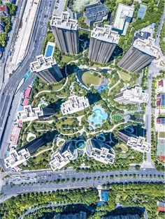 an aerial view of a city with lots of buildings and trees in the middle of it