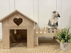 a small dog house next to a potted plant with a heart on the top