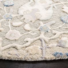 a white and blue rug on top of a wooden floor