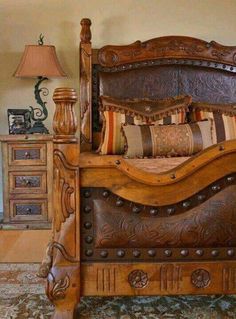 a large wooden bed sitting on top of a carpeted floor next to a night stand