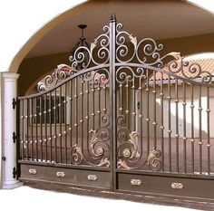 an ornate iron gate is opened to reveal a driveway