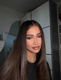 a woman with long brown hair is looking at the camera