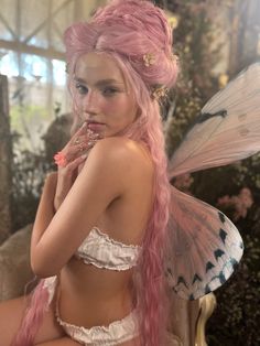 a woman with pink hair wearing a fairy costume