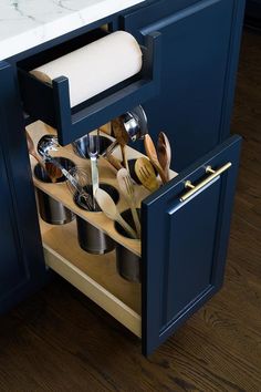 an open cabinet with utensils and spoons in it