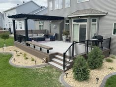 a deck with stairs and patio furniture in the back yard