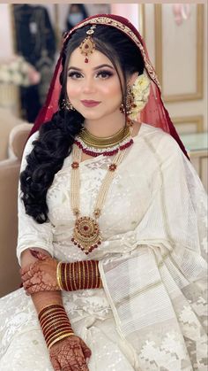 a woman wearing a bridal outfit and jewelry