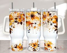 three white and yellow floral tumblers sitting on a counter