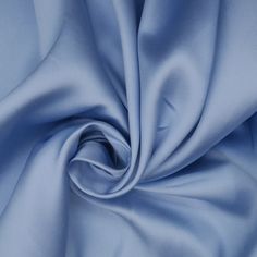 a close up view of a blue fabric with very soft folds and smooth lines on it