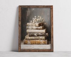 an old wooden frame with some books stacked on top of each other in front of a white wall