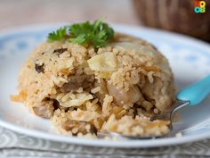 a white plate topped with rice covered in meat and garnished with parsley