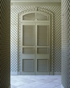 an open door in the middle of a room with latticed walls and flooring