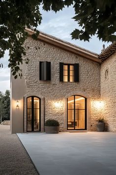 an exterior view of a house with stone walls and black shutters