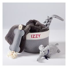 two stuffed animals are in a basket with the word lizy on it's side