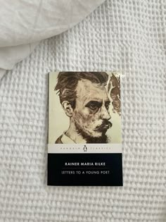 a book with an image of a man's face on it sitting on top of a bed