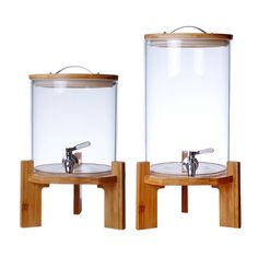 two glass containers with wooden stands holding water