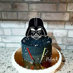 a darth vader cake on top of a white plate next to a brick wall