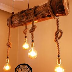 several light bulbs hanging from a wooden beam with rope wrapped around them and plugged into the ceiling