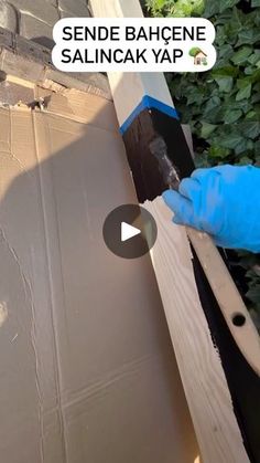 a person in blue gloves is painting a box