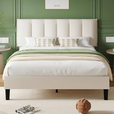 a bedroom with green walls and a white bed in the middle is decorated with modern furniture