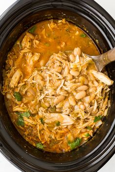 a slow cooker filled with chicken and beans