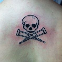 a skull and two crossed swords tattoo on the back of a man's chest