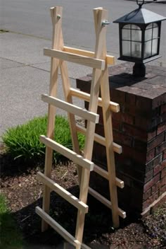 a wooden ladder leaning against a brick wall next to a lamp post and street light