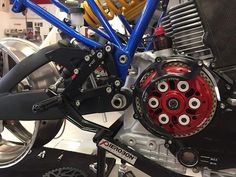 a close up of a motorcycle engine with red and blue parts