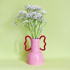 a pink vase with white flowers in it