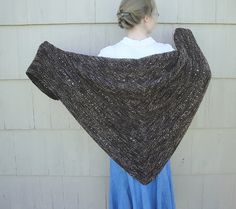 a woman wearing a brown shawl standing in front of a white wall with the words espresso shawl knitting pattern on it