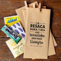 three brown paper bags with different types of food on top of each bag and some candy bar wrappers in front of them