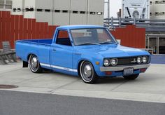 a blue pickup truck parked in front of a building