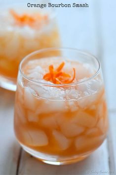 two glasses filled with orange bourbon smash