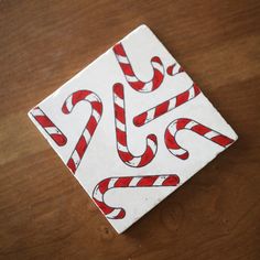 candy canes are painted on the side of a square tile