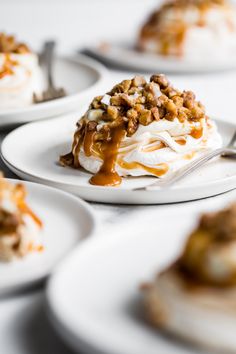 there are many desserts on white plates with caramel drizzle and pecans