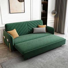 a green couch sitting on top of a gray rug