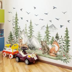 a child's room with a wall mural featuring bears and birds in the woods