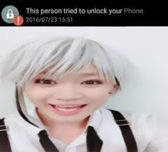 a person with white hair and suspenders smiling