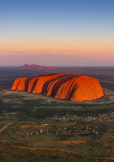 an orange rock in the middle of nowhere