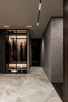 an empty walk in closet with clothes hanging on the racks and lights above it,