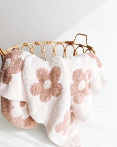 two towels hanging on a bamboo rack with white and pink flowered toweling in the foreground